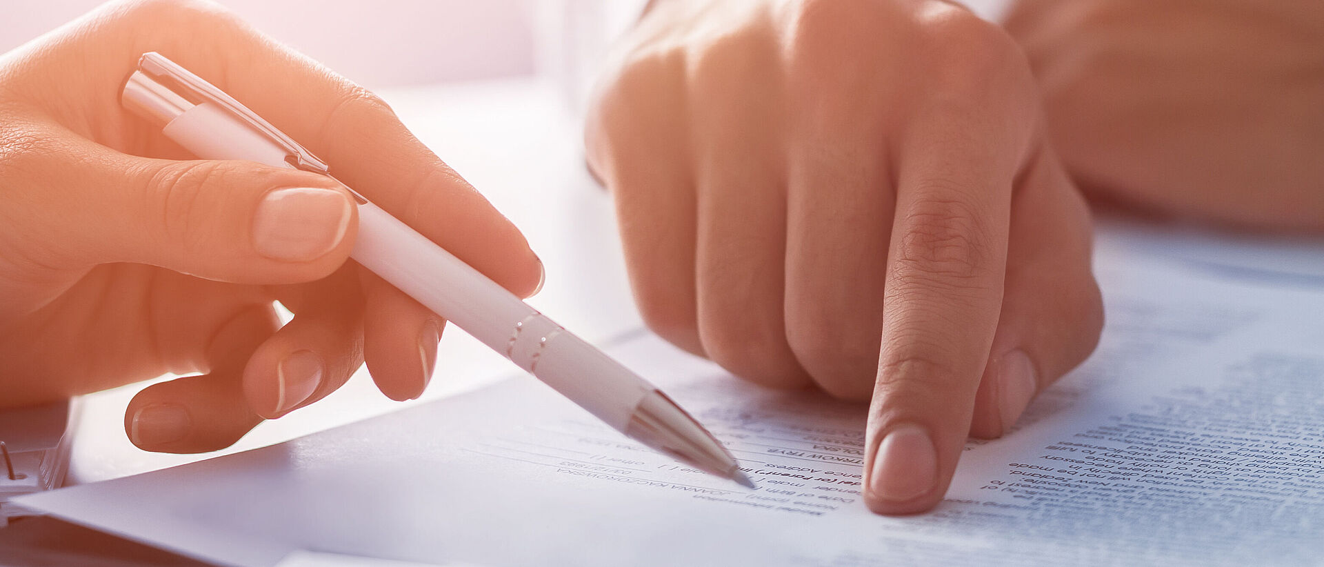 a finger and a pencil pointing at a text