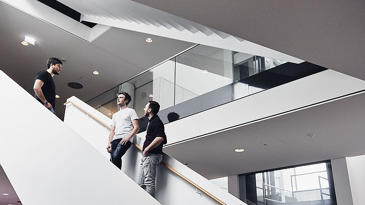 three RENA employees talking on the staircase