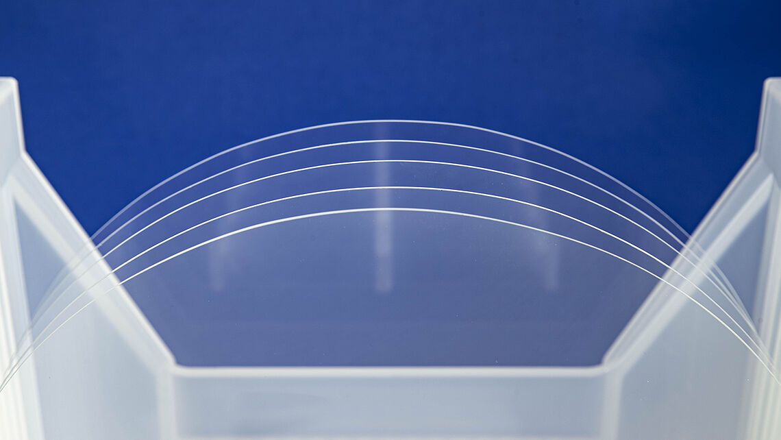 clear glass wafers in front of the blue background 