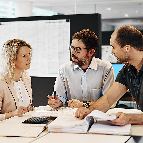 four RENA employees discussing some documents in the office