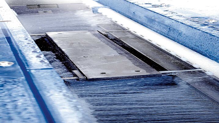 Cut wafers are cleande by spray nozzles