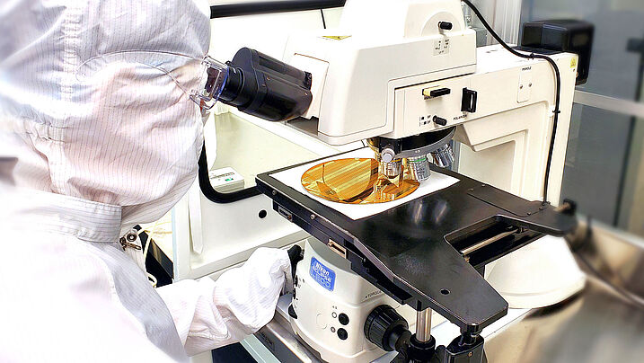 an employee looking at a microscope